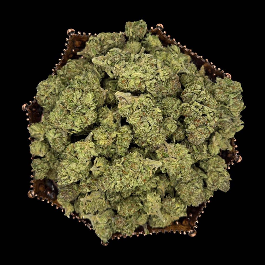 Greenhouse THCA flower buds arranged in a hexagonal copper tray, photographed on black